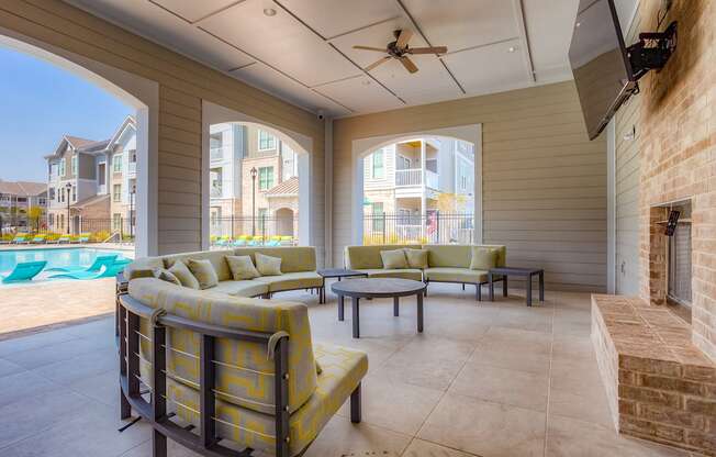 a covered patio with couches and a fireplace