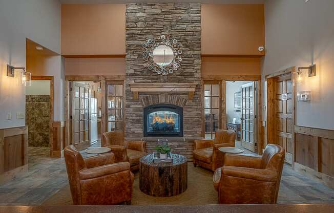 Quail Springs clubhouse with large stone fire place and 4 leather chairs