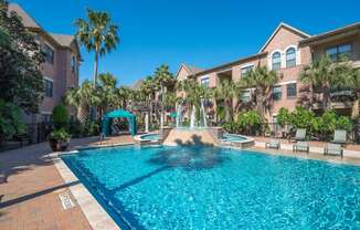 A swimming pool surrounded by palm trees and lounge chairs.