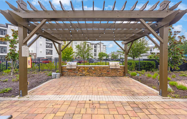 a brick patio with a wooden pergola and a brick wall