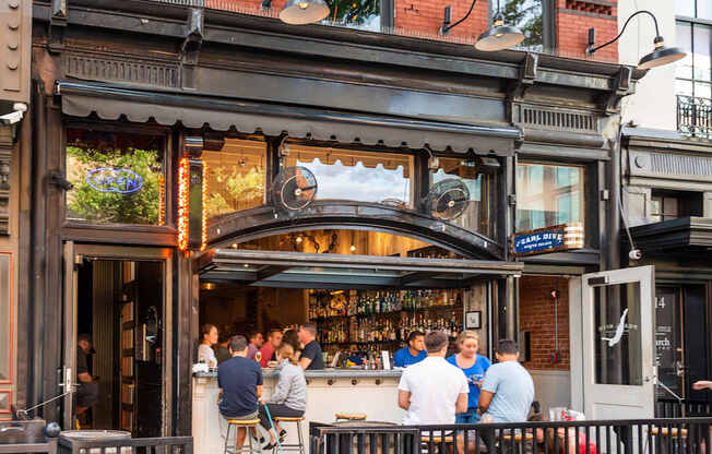 A group of people are sitting at a bar with a sign that says
