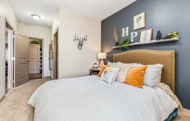 a bedroom with a large bed and a blue accent wall