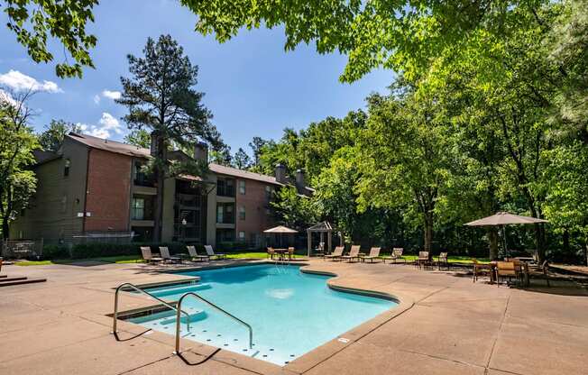 our apartments offer a swimming pool with chairs and trees at The Summit Apartments, Memphis, 38128