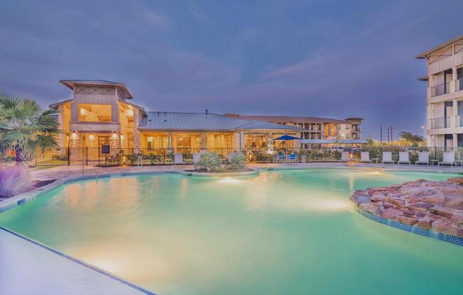 A large building with a pool in front of it.