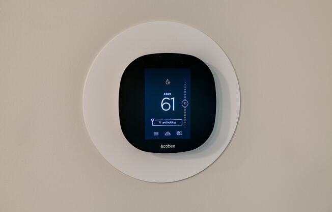 a digital thermostat on a white wall