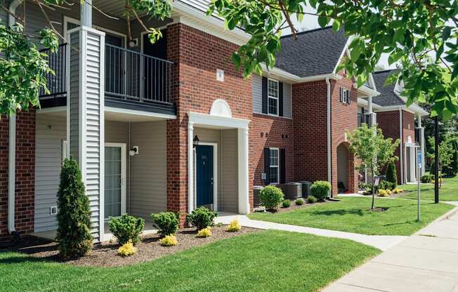 a brick building with a porch and a sidewalk