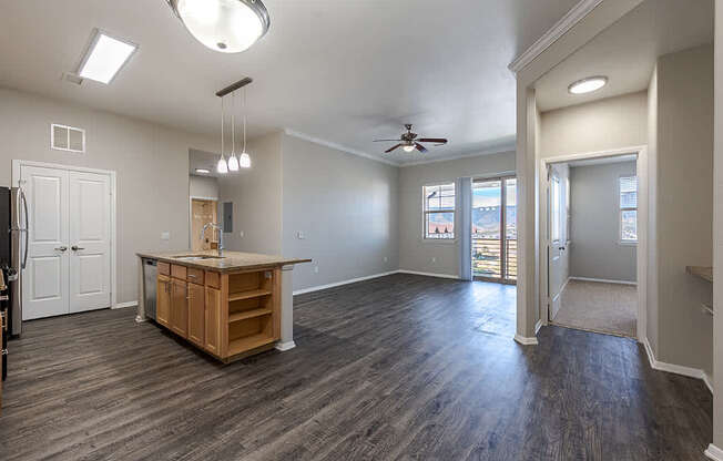 A spacious room with a kitchen island and wood flooring.