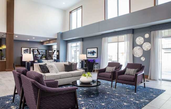 A living room with purple chairs and a grey couch.
