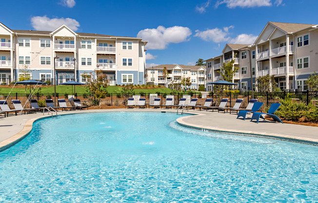 A large swimming pool in front of apartment buildings.