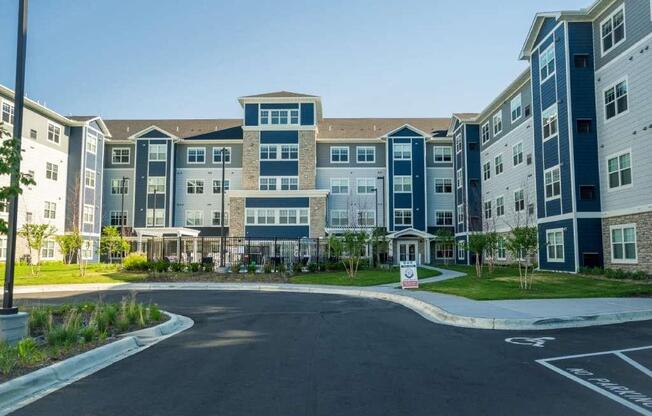 A large apartment complex with a road in front.