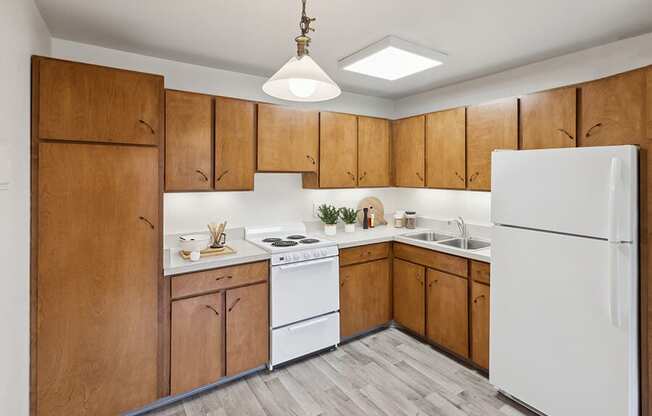 Model Kitchen with Dark Wood Cabinets and Wood-Style Flooring at Walnut Creek Apartments located in Walnut Creek, CA.