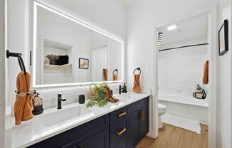 a bathroom with black cabinets and white walls