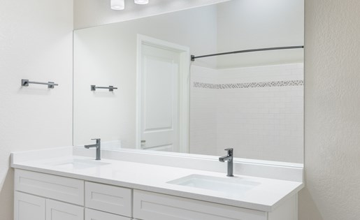 Renovated bathroom with white cabinets