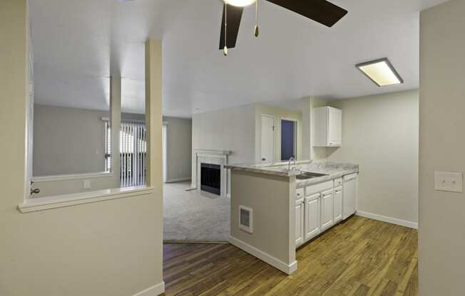 a kitchen and living room in an apartment with a ceiling fan at Serra Vista Apartment Homes, WA 98087