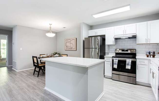 A kitchen with a white island and stainless steel appliances.