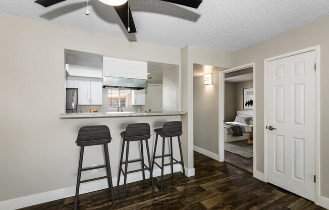 a kitchen with a breakfast bar and three stools in front of it