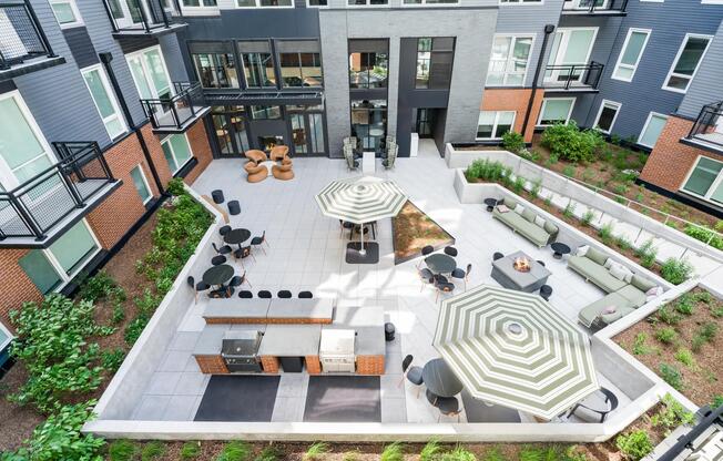 Interior courtyard with lounge seating, café tables, and grilling stations arranged around landscaped planters for shared outdoor time.