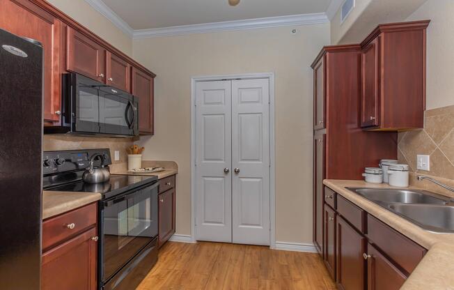 a large kitchen with stainless steel appliances and wooden cabinets