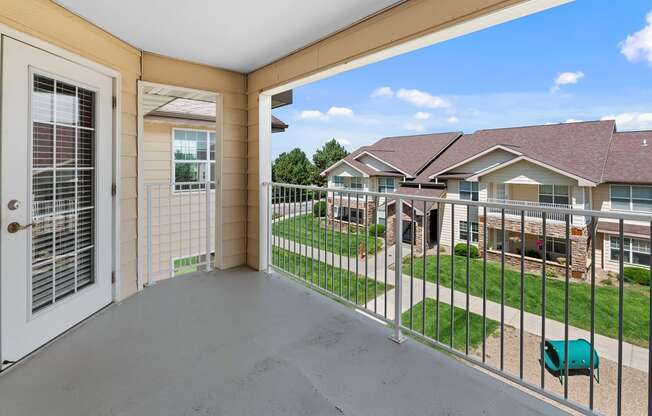 the view from the balcony of a house with a yard and a white door