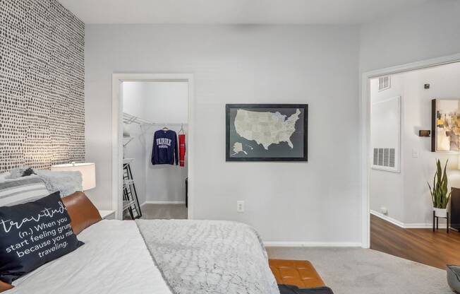 a bedroom with a bed and a closet and a map on the wall