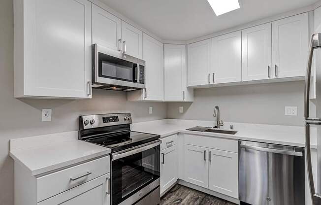 A kitchen with white cabinets and stainless steel appliances.