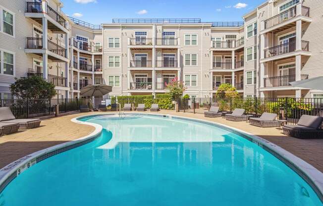A swimming pool in front of apartment buildings.