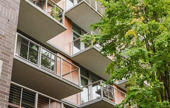 A building with balconies and windows surrounded by trees.