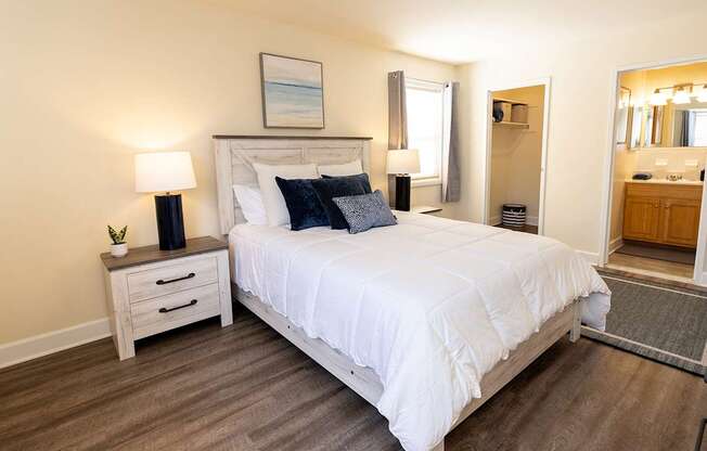 A bedroom with a large bed, a nightstand with a lamp, and an area rug.