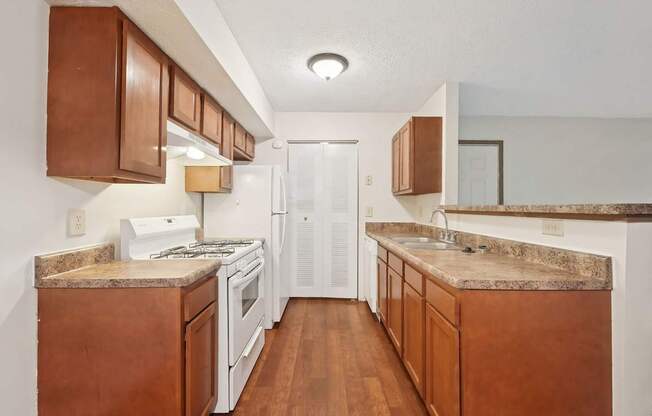 A kitchen with brown cabinets and a white fridge.
