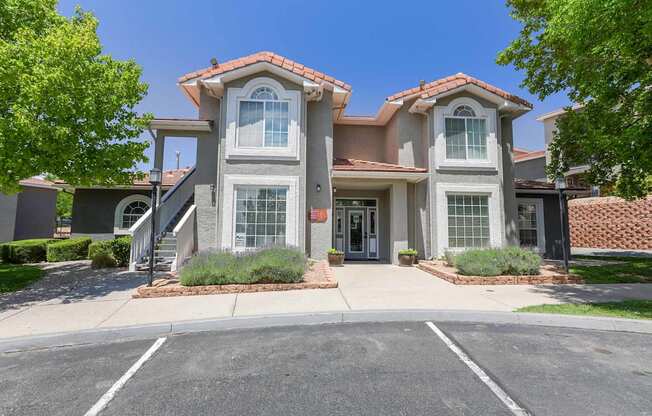 A two-story house with a red tile roof and a driveway in front.