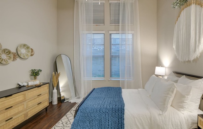 a bedroom with white walls and a bed with a blue blanket