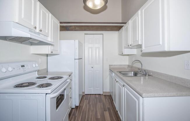 Renovated kitchen with white cabinets and all white appliances at Foster Creek apartments