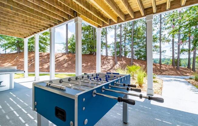 a foosball table in the shade of a pavilion