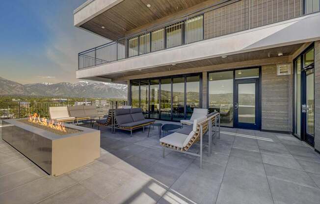 A modern patio with a fire pit and seating area.