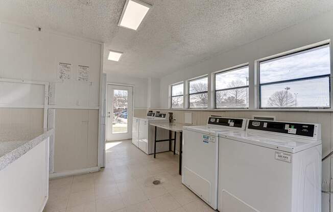 A laundry room with washers and dryers.