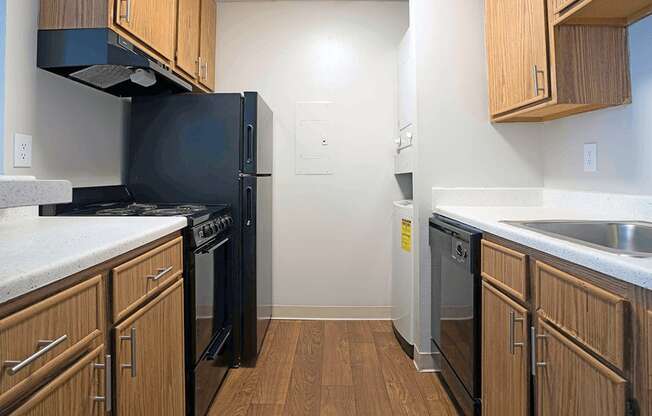 a kitchen with wooden cabinets and a black refrigerator