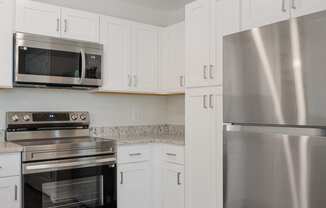 a kitchen with stainless steel appliances and white cabinets