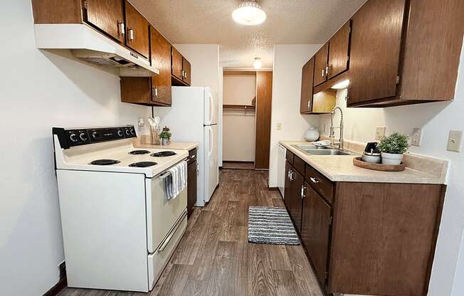 A kitchen with a white stove and brown cabinets.