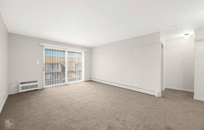 a living room with a large window and a carpeted floor