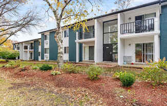 A row of modern townhouses with white and green exteriors.