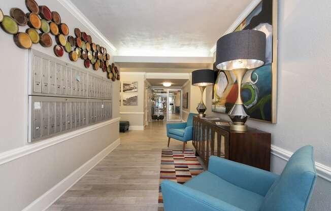 a hallway with blue couches and chairs and a large painting on the wall