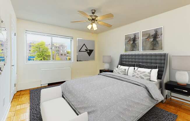 bedroom with wood flooring, bed, night stands, ceiling fan, and large windows at chillum place apartments in washington dc