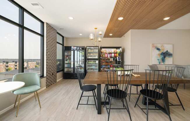 A room with a table and chairs and a fridge.