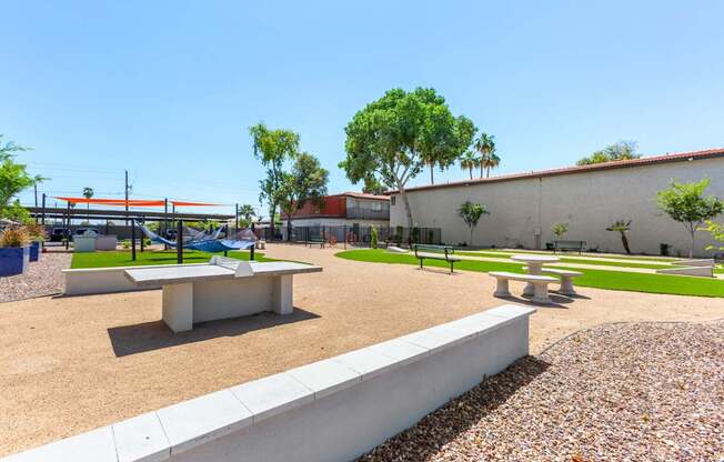 A park with a picnic table and benches.