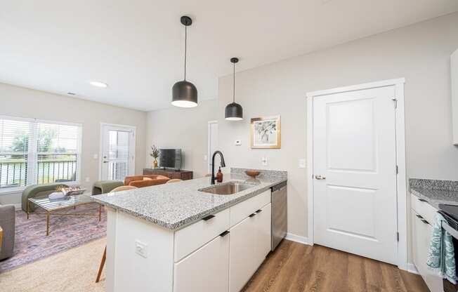 a kitchen with a counter top and a door to a living room
