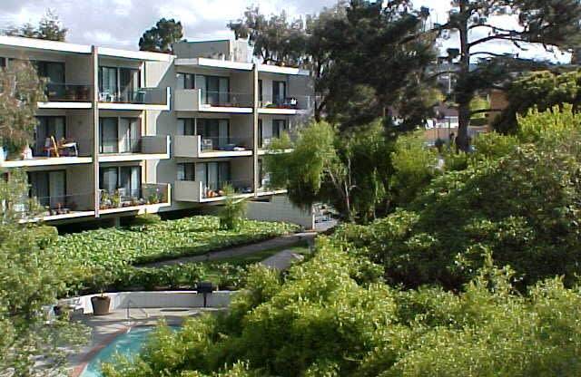 a view of an apartment building with trees in the foreground