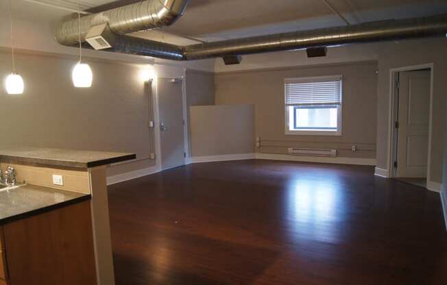 an empty living room with wood floors and a window at Residences at South High, Pittsburgh ? 