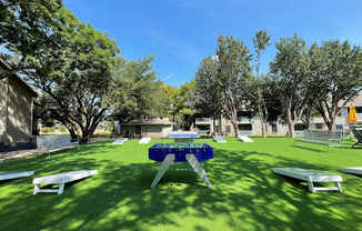 a picnic table in a yard with benches and picnic tables at Polo Clubs Apartments, Texas