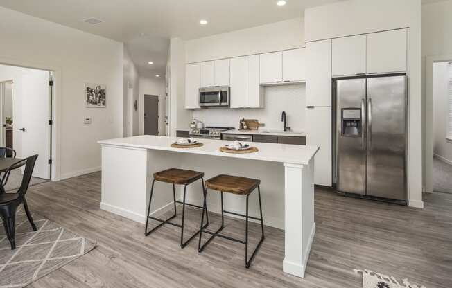 a kitchen with a large island with two stools