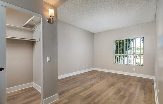 Empty room with wood flooring and a window.